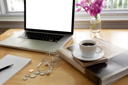Cup of coffee on wooden desk with laptop computer and pen.の写真素材