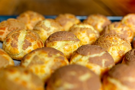 Fresh fresh Choux cream or eclair in a tray on wwooden tableの写真素材