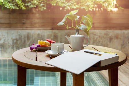 Selected focus cup of coffee and open notebook with pen on the wooden tableの写真素材