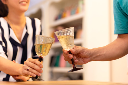 Couples celebrate with white wine in the house.の写真素材