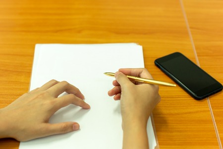 Hand holding pen to taking notes on paperwork at conference meeting room.の写真素材