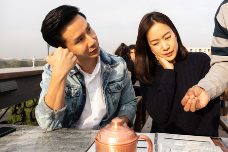 Waiter talking with the couple clients before serving tea and foodsの写真素材