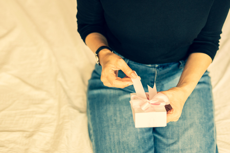 Woman hands opening valentine presents in cross process color.の写真素材
