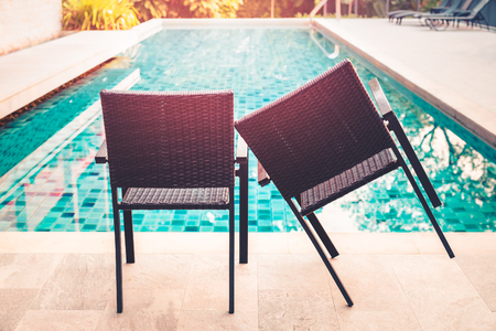 Conceptual coupel comfortable chair by swimming pool with sunlight.の写真素材
