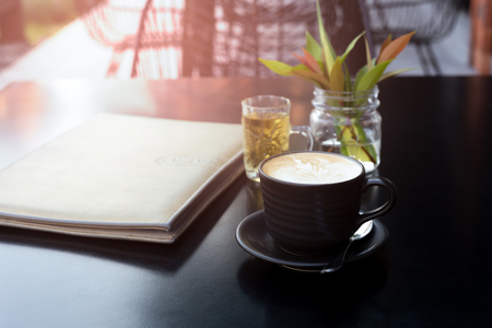 Coffee cup with menu list on black tabe.の写真素材