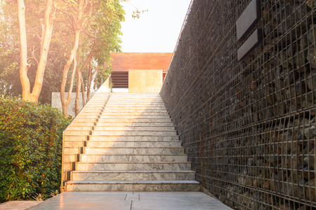 Outdoors modern marble stairs with glass and stone wall and tree.の写真素材