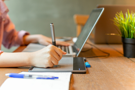 Graphic designer using digital tablet with laptop on the desk.の写真素材