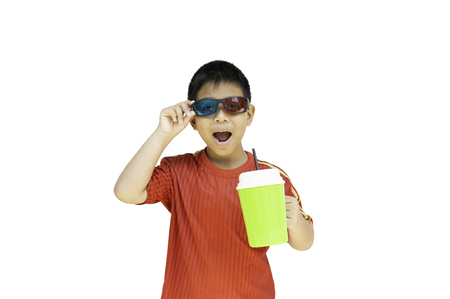 Asian boy with 3D glasses holding plastic cup isolation in clipping path.の写真素材
