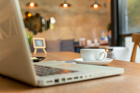 Cup of coffee with laptop on table  in coffee shop.の写真素材
