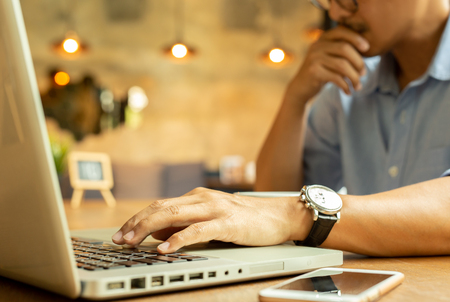 Cropped image of  businessman working on his laptop in a coffee shop.の写真素材