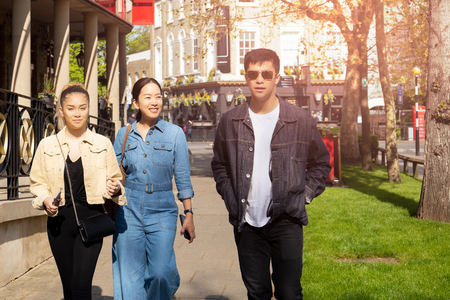 Happy mother and mixed race teen walking on the street in summer.の写真素材