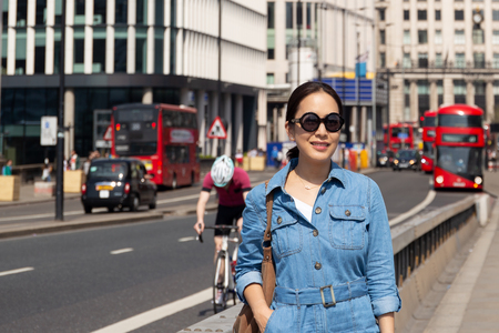 Beautiful asian woman with black sunglasses walking on london bridge.の写真素材