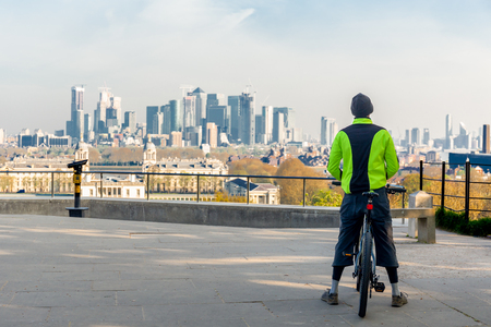 Man standing on bicycle look over city view in the morning.の写真素材