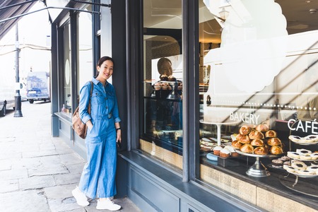 Beautiful woman standing in front of coffee shop.の写真素材