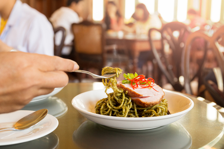 Female having Spaghetti with pesto sauce for lunch in the restaurant.の写真素材