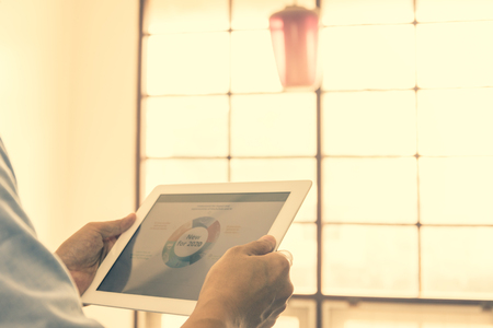 Business man working on the Tablet with 2020 goals stock market chart.の写真素材