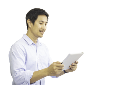 Businessman working on the tablet isolated in clipping path.の写真素材