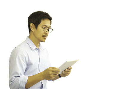 Asian man with eyeglasses looking at tablet isolated in clipping path.の写真素材