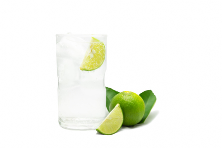 Glass of sparkling water soda with ice and lime slice on white background.の写真素材