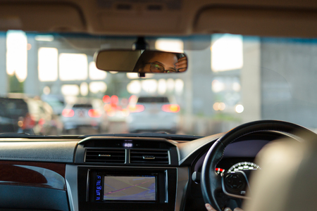 Woman looking bored in her car while stuck in traffic jamの写真素材