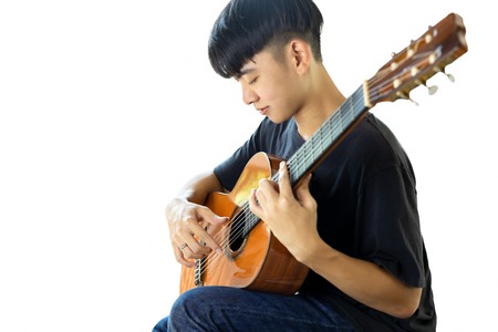 Asian man playing a classic guitar isolated