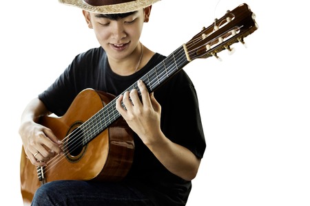 Asian man playing classic guitar isolated on white  in high contrast.の写真素材