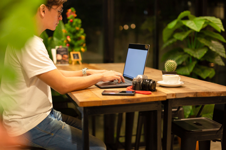 Male freelancer working on laptop at late night in coffee shop.の写真素材