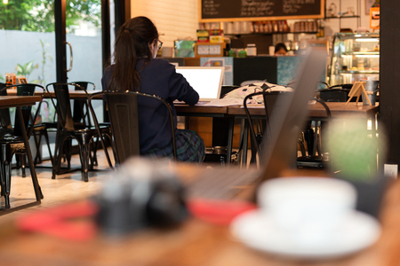 Young woman student working with laptop in cafe.の写真素材