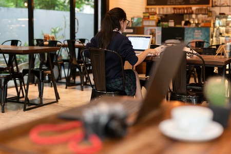 Young woman student working with laptop in cafe.の写真素材