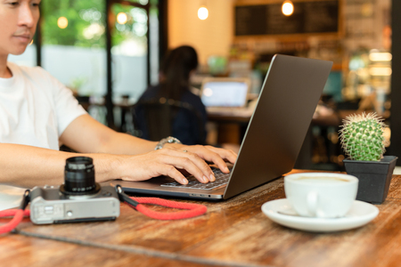 Male freelancer working on laptop at late night in coffee shop.の写真素材