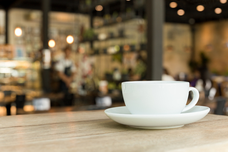 Cup of coffee on wooden table in cafe with blurredの写真素材