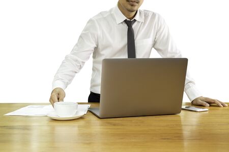 Businessman hand holding coffee cup with laptop on wooden desk in clipping path.の写真素材