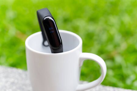 Health care concept Fitness bracelet on coffee cup display of foot step in blurの写真素材