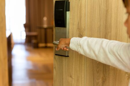 Children hands open the door in hotel room.の写真素材