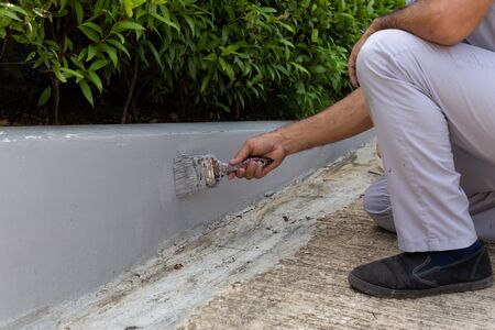 Man worker painting concrete wall with paintbrush.の写真素材