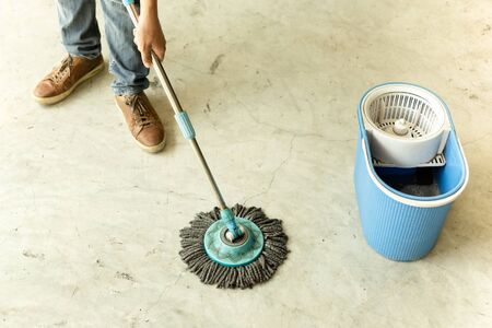 Man worker with mop cleaning floor in the cafe.の写真素材
