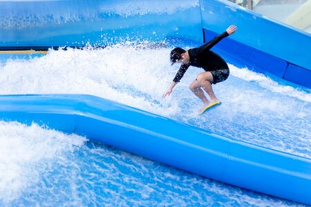 Unidentified man playing surfboard indoor extreme sport.の写真素材
