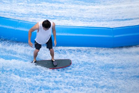 Unidentified man playing surfboard indoor extreme sport.の写真素材