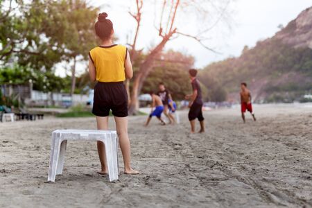 Selected focus group of friends playing soccer on the beach in summertime.の写真素材