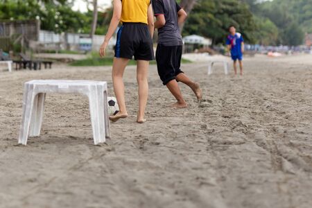 Selected focus group of friends playing soccer on the beach in summertime.の写真素材