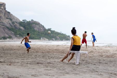 Selected focus group of friends playing soccer on the beach in summertime.の写真素材