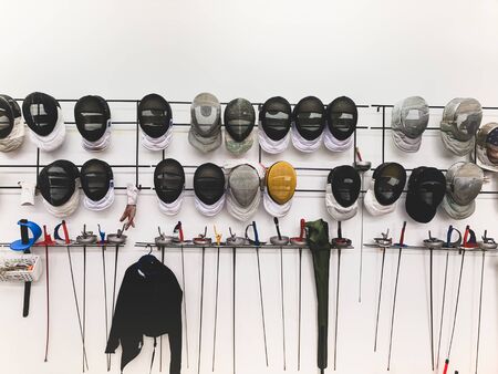 Group of fencing masks and sword hanging on the wall.の写真素材