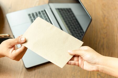 Businessman taking bribe money in brown envelope from partner.の写真素材
