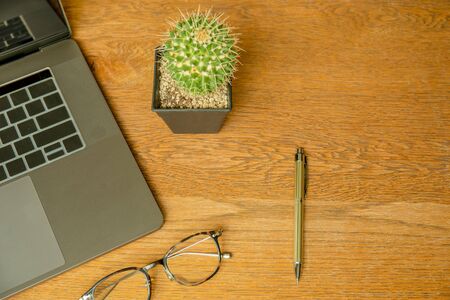 Top view of office desk with laptop, eyeglasses and pen.の写真素材