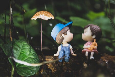 Two little dolls about to kiss sitting under the Gathering mushrooms.の写真素材