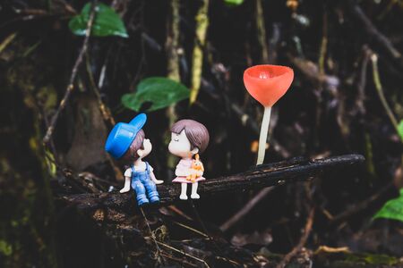 Two little dolls about to kiss sitting under the champagne mushroom.の写真素材