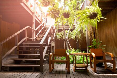 Wooden stair with arm chair and plant in terrace.の写真素材