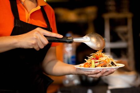 Woman making Thailand spicy papaya salad with crab in restaurantの写真素材