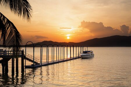 Speed boat on the floating pier with beautiful sunset in background.の写真素材