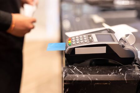 Cashier using credit card machine for customer shopping payment in store.の写真素材